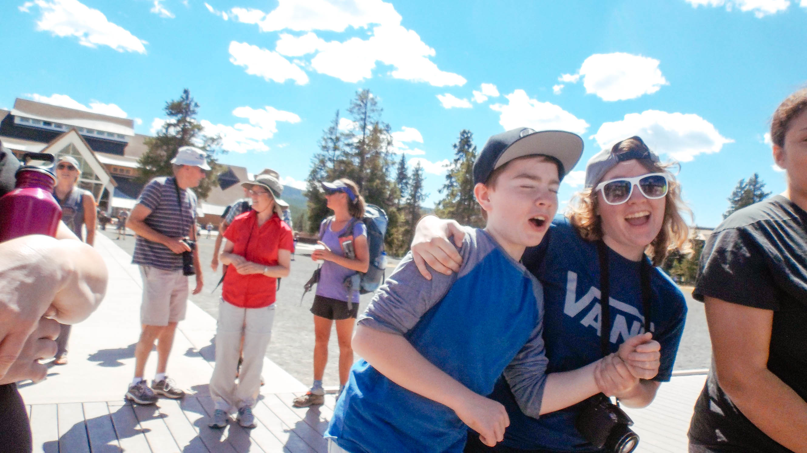 Cousins horsing around at Old Faithful in Yellowstone whilst camping together.