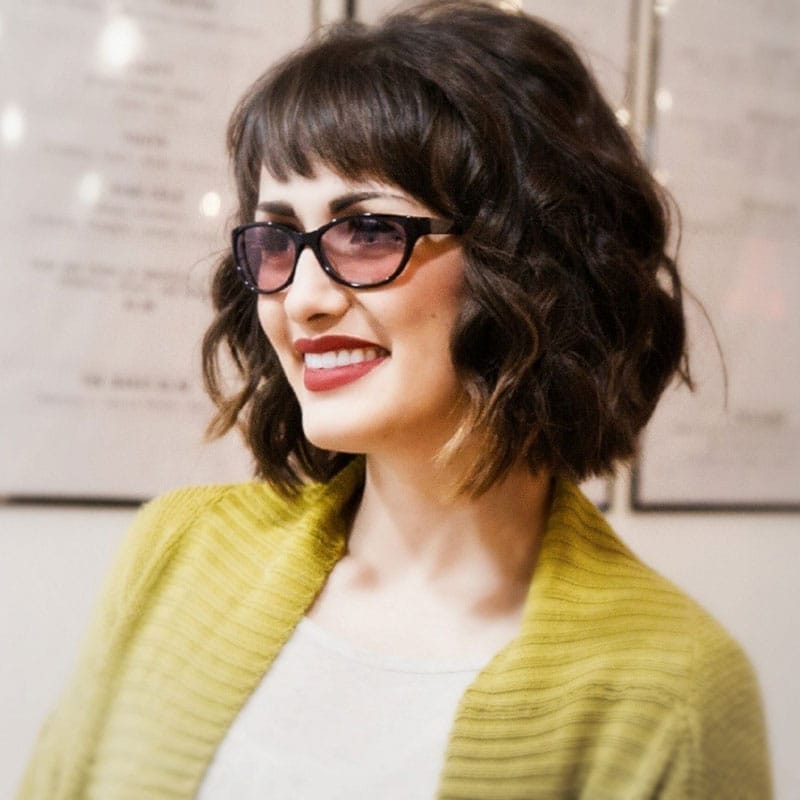 A woman wears the Dalliance migraine glasses from Axon Optics.